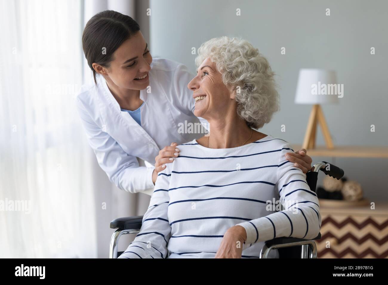 Infermiere positivo prendersi cura di donne anziane disabili Foto Stock