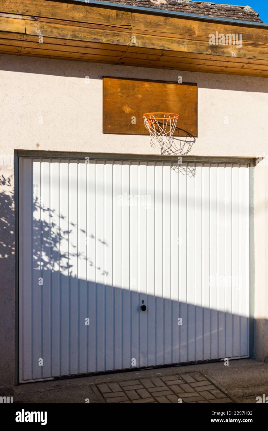 Porta del garage chiusa con rete da basket fissata sopra Foto Stock