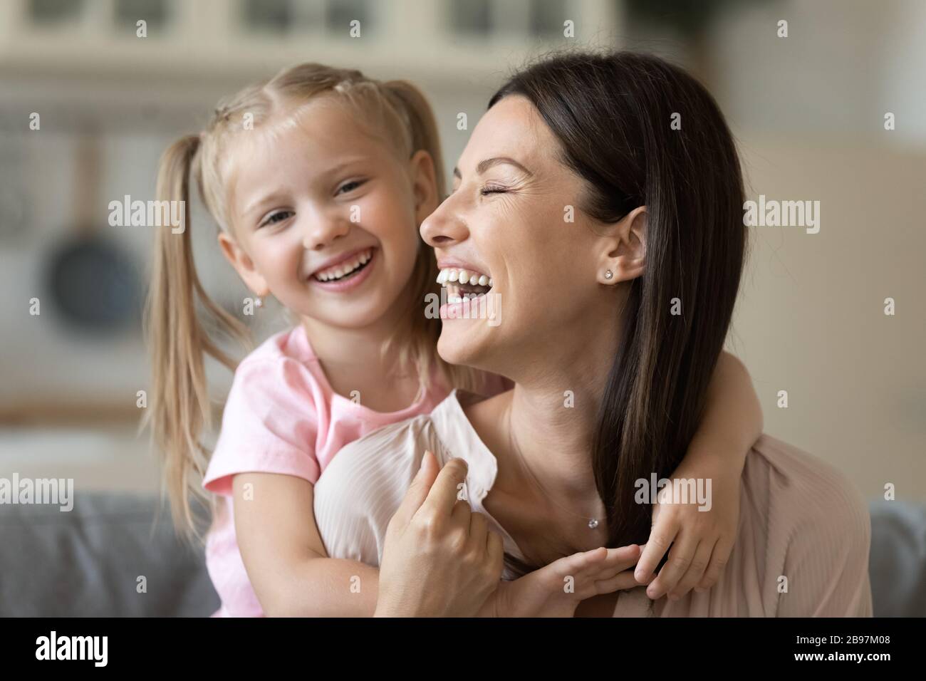 Mamma felice e figlia coccole a casa Foto Stock