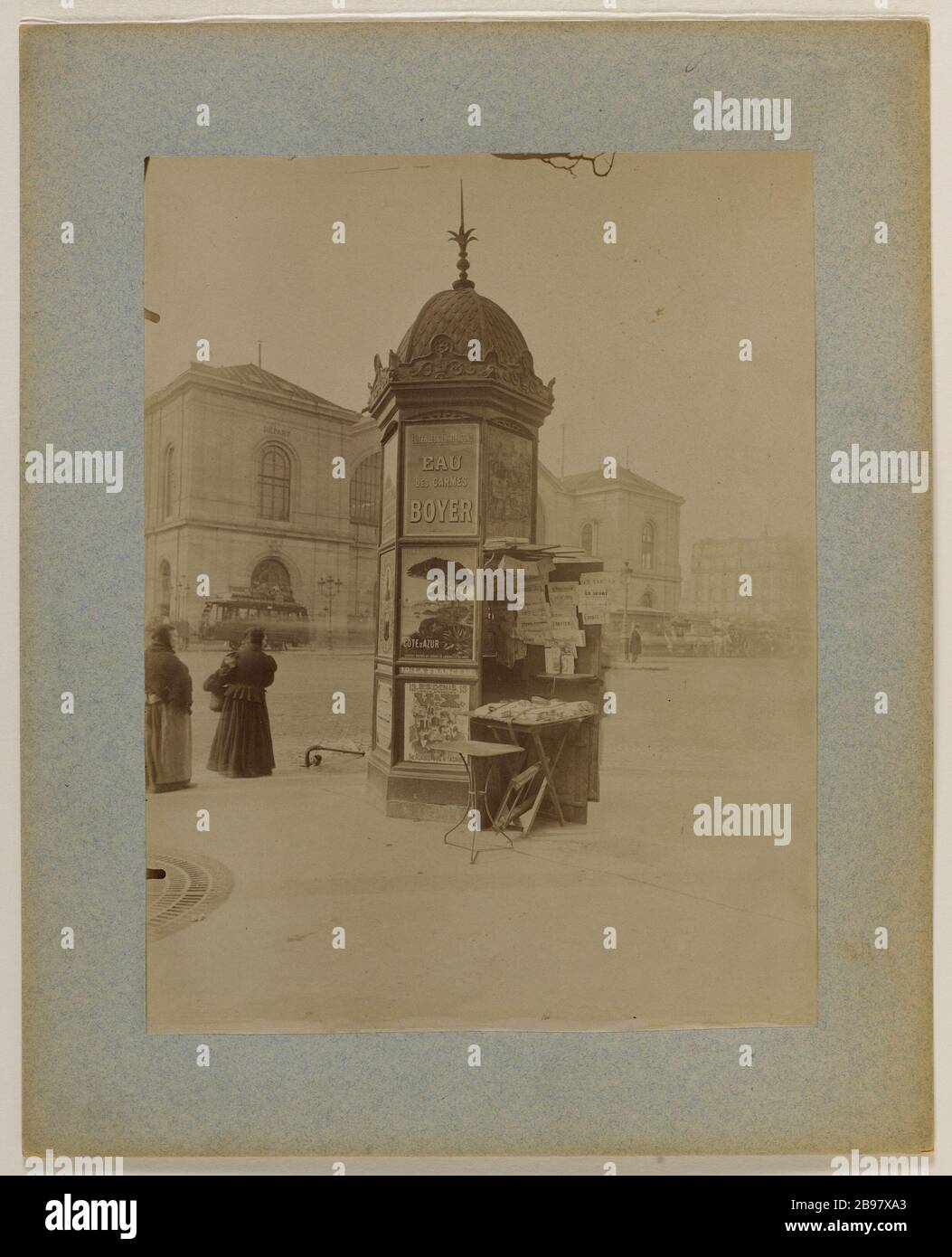 MERCANTE DI GIORNALI VICINO A MORRIS COLONNA PLACE DE RENNES, VECCHIA Gare Montparnasse, 14 ° DISTRETTO, PARIGI Marchand de journaux près d'une colonne Morris, Place de Rennes, ancienne gare Montparnasse, Parigi (XIVème arr.), 1898. Photographie d'Eugène Atget (1857-1927). Parigi, musée Carnavalet. Foto Stock