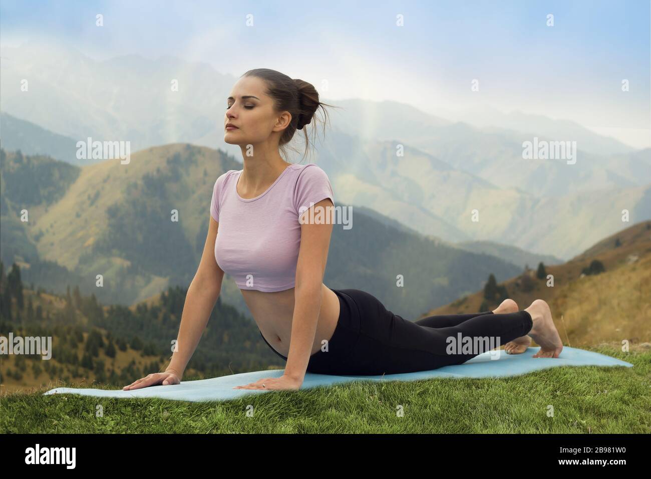 Yoga all'aperto - donna che fa yoga Surya Namaskar Sun Salutation asana Urdhva Mukha Svanasana - verso l'alto posa cane in montagna al mattino. Foto Stock