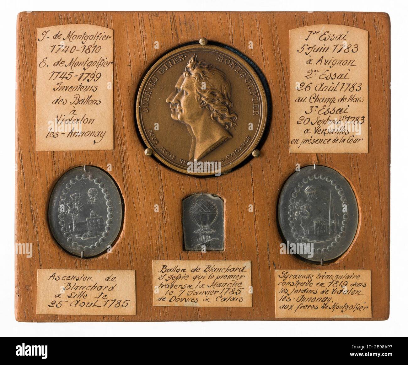 Piatto di legno che sono inseriti una moneta e prove di stagno commemorare salite mongolfiere e Blanchard, 1785-1819 Anonyme. Plaque de bois où sont insérées une maydaille et des épreuves en étain commémorant les ascensions des ballons de Montgolfier et de Blanchard, 1785-1819. Après 1819. Parigi, musée Carnavalet. Foto Stock