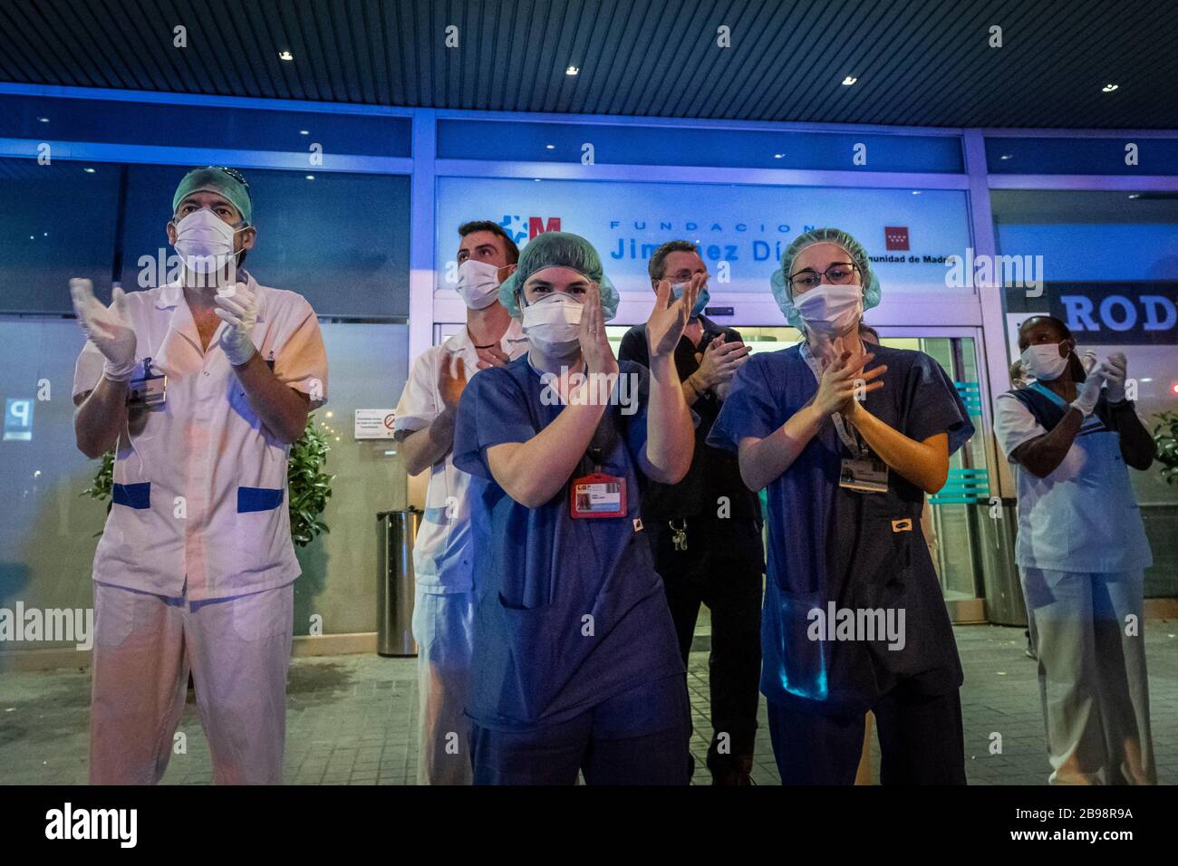 Il personale medico si è rivolto all'ingresso dell'ospedale Fundación Jiménez Díaz di Madrid per ringraziare le persone che li hanno appoggiati mentre combattono contro il coronavirus. Tutti i giorni dal momento che il blocco è stato fissato il 14 marzo, madrilenos prendere ai loro balconi per applaudire e sostenere il personale medico che stanno combattendo contro il coronavirus. Foto Stock