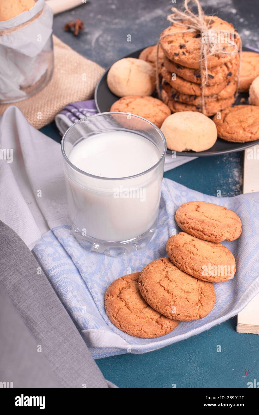 Tazza di latte con biscotti e pinzette Foto Stock