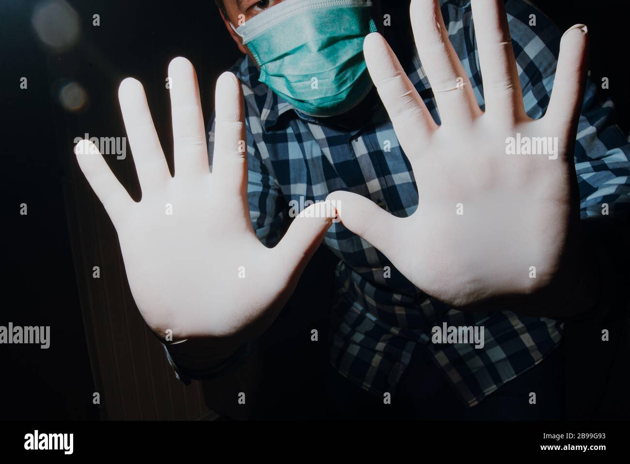 uomo affraid mani sociale con guanti e maschera medica per la protezione dal virus corona covid-19 Foto Stock