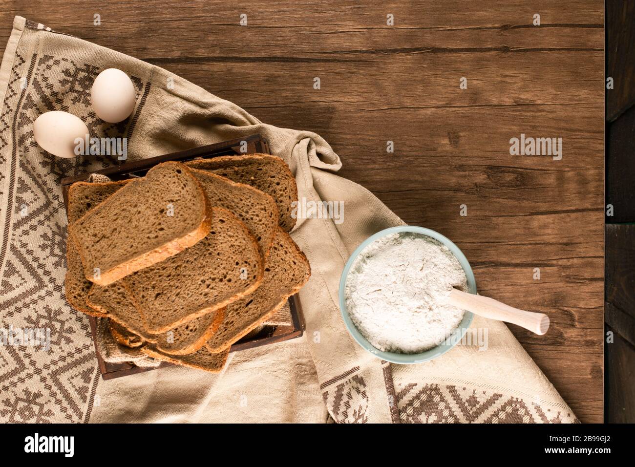 Uova con fette di pane e ciotola di farina Foto Stock