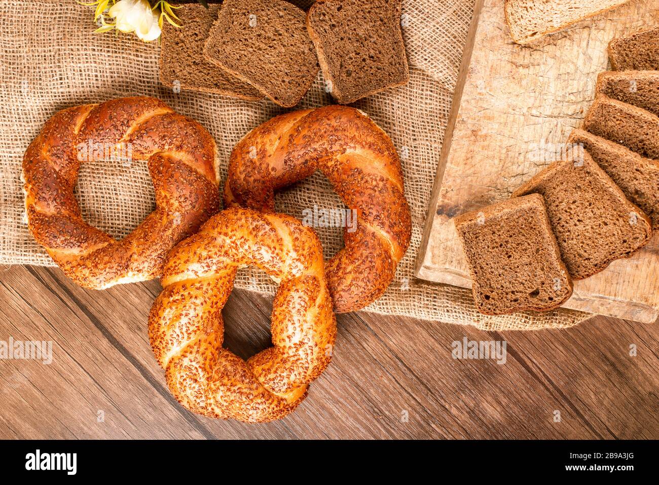 Bagel e fette di pane nel cesto e sulla tovaglia Foto Stock