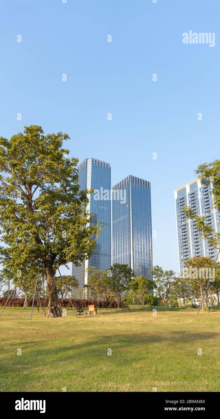 Un alto edificio e due sedie vicino al Parco della Baia di Shenzhen Foto Stock