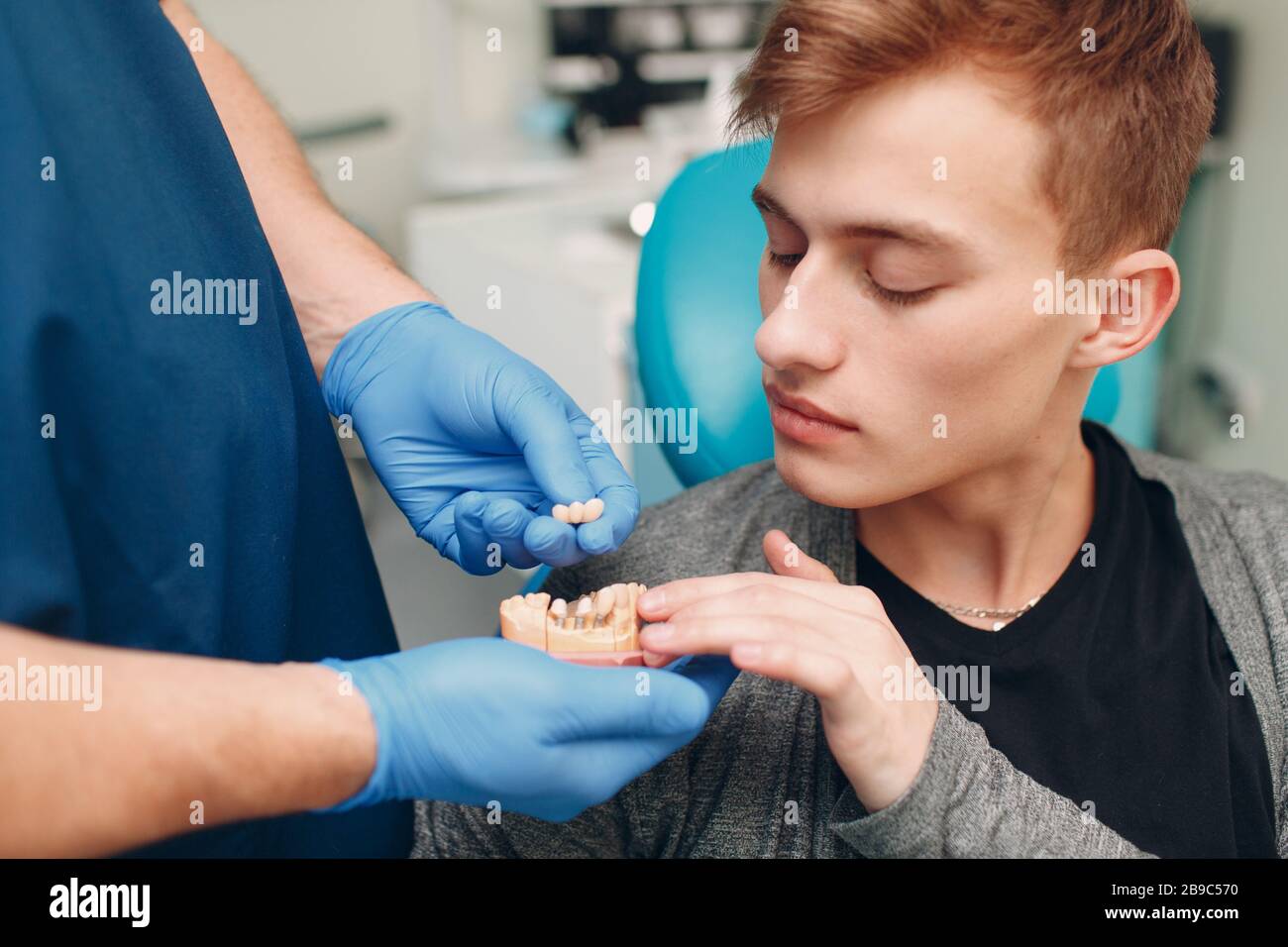 Odontoiatria. Il dentista mostra impianti al paziente. Clinica dentale. Foto Stock