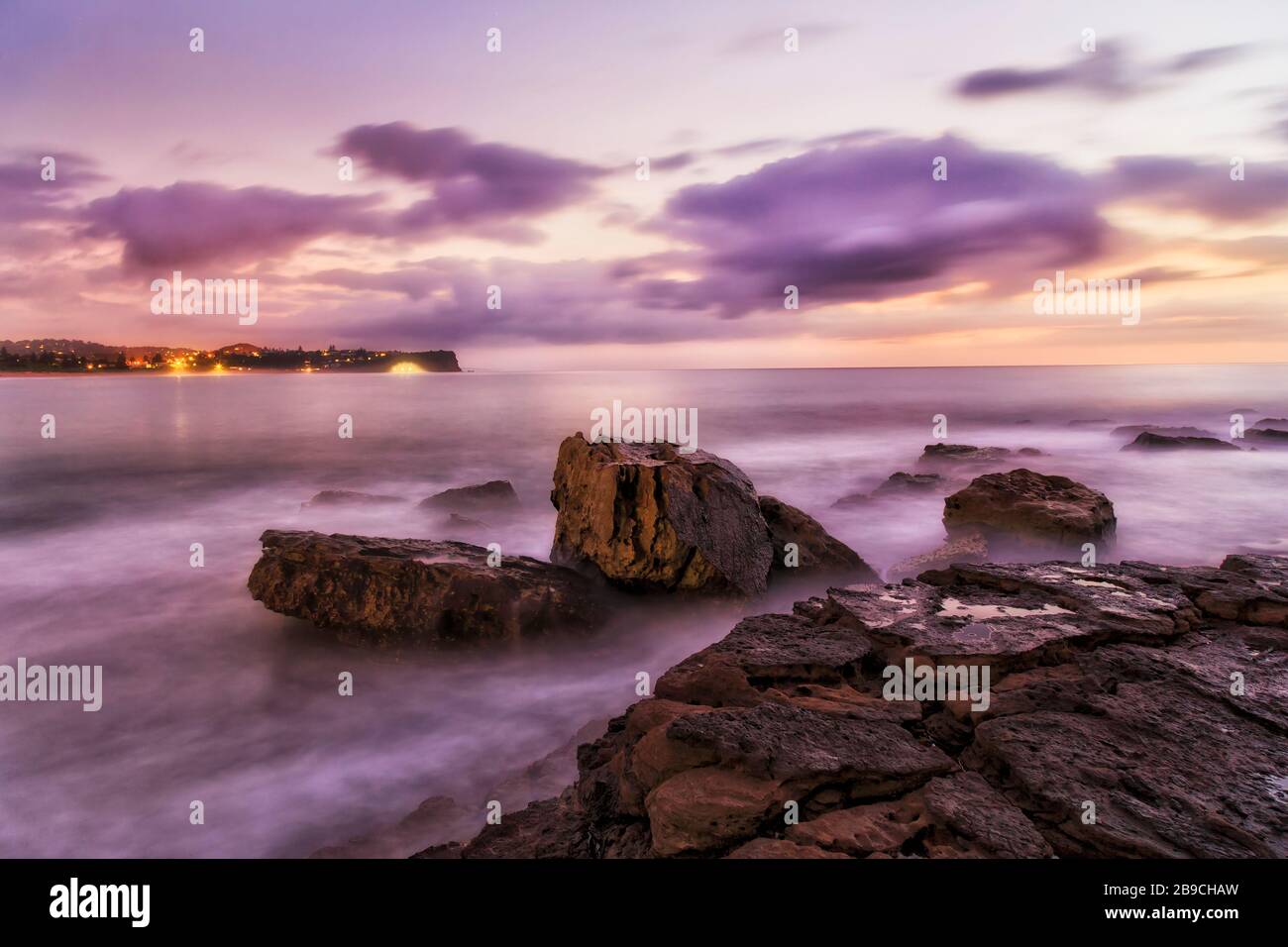 Rocce di arenaria bagnate di Turimetta dirigiti verso le spiagge settentrionali di Sydney all'alba. Foto Stock