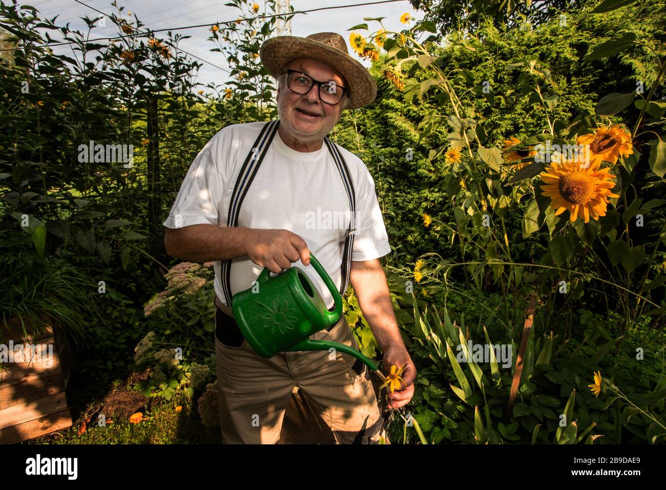 giardiniere nel suo giardino con vaso d'irrigazione Foto Stock