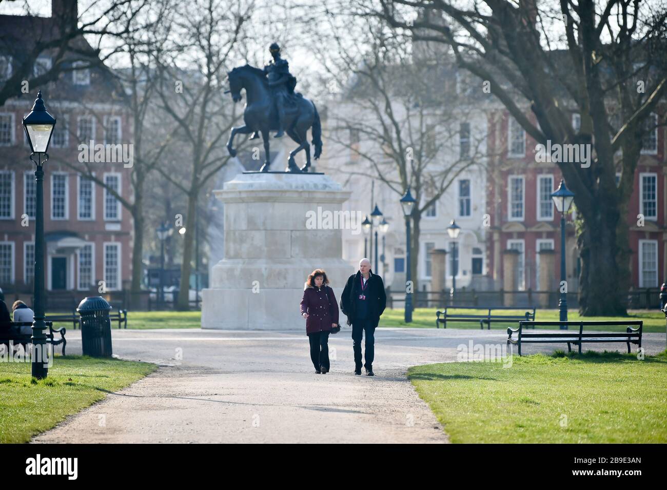 Due persone camminano attraverso Queens Square, Bristol, che è vuoto di pendolari di punta alle 8:20 il giorno dopo che il primo ministro Boris Johnson ha messo il Regno Unito in blocco per contribuire a frenare la diffusione del coronavirus. Foto Stock