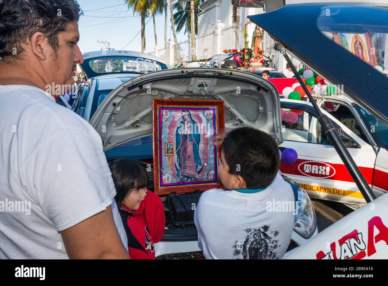 Padre e figlio in taxi decorato prima della processione, Festival di nostra Signora di Guadalupe, strada a Catemaco, Veracruz Stato, Messico Foto Stock