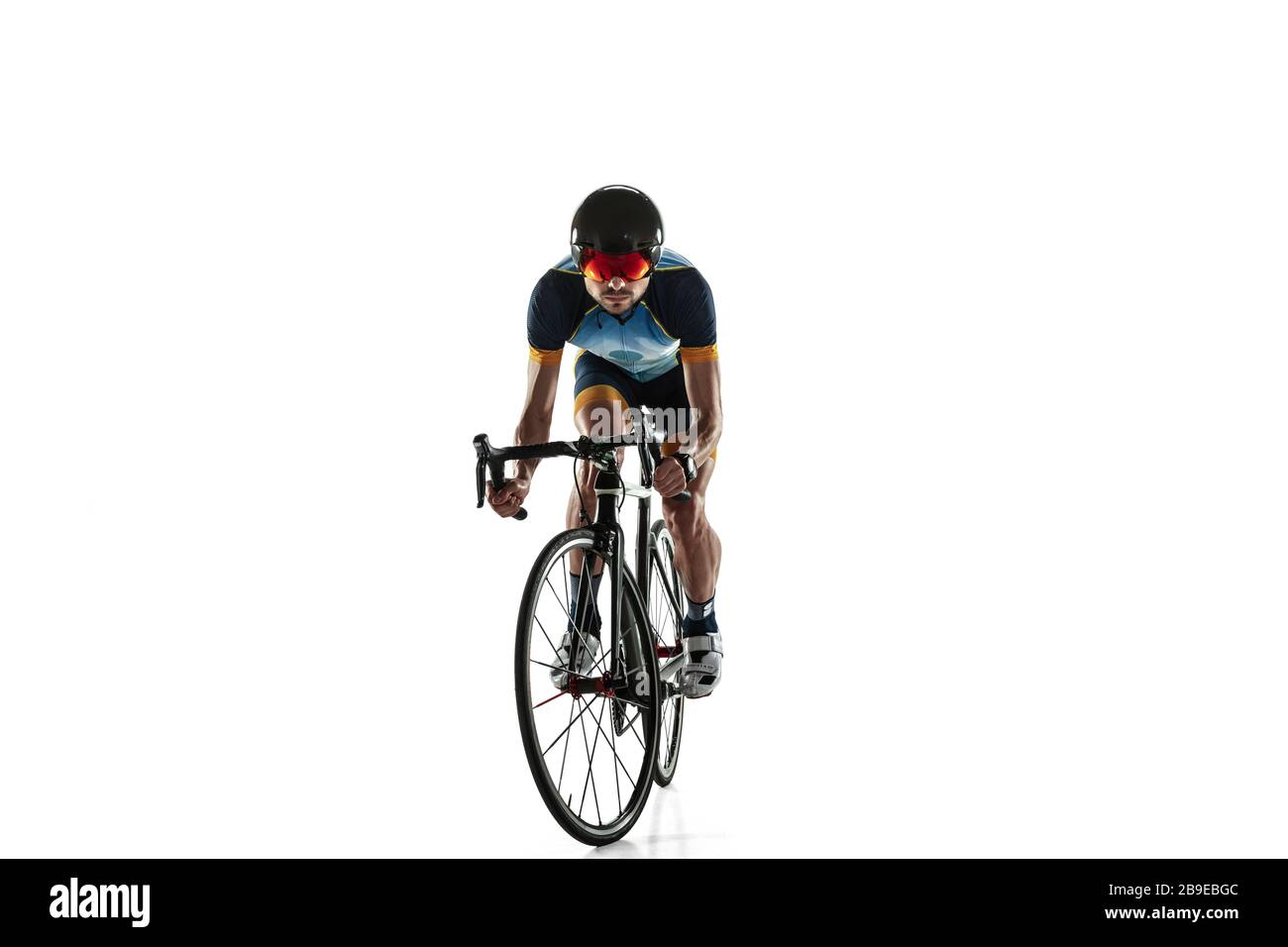 Triathlon atleta maschile ciclo di allenamento isolato su sfondo bianco studio. Il triatleta caucasico si esercita in bicicletta indossando attrezzature sportive. Concetto di stile di vita sano, sport, azione, movimento. Foto Stock