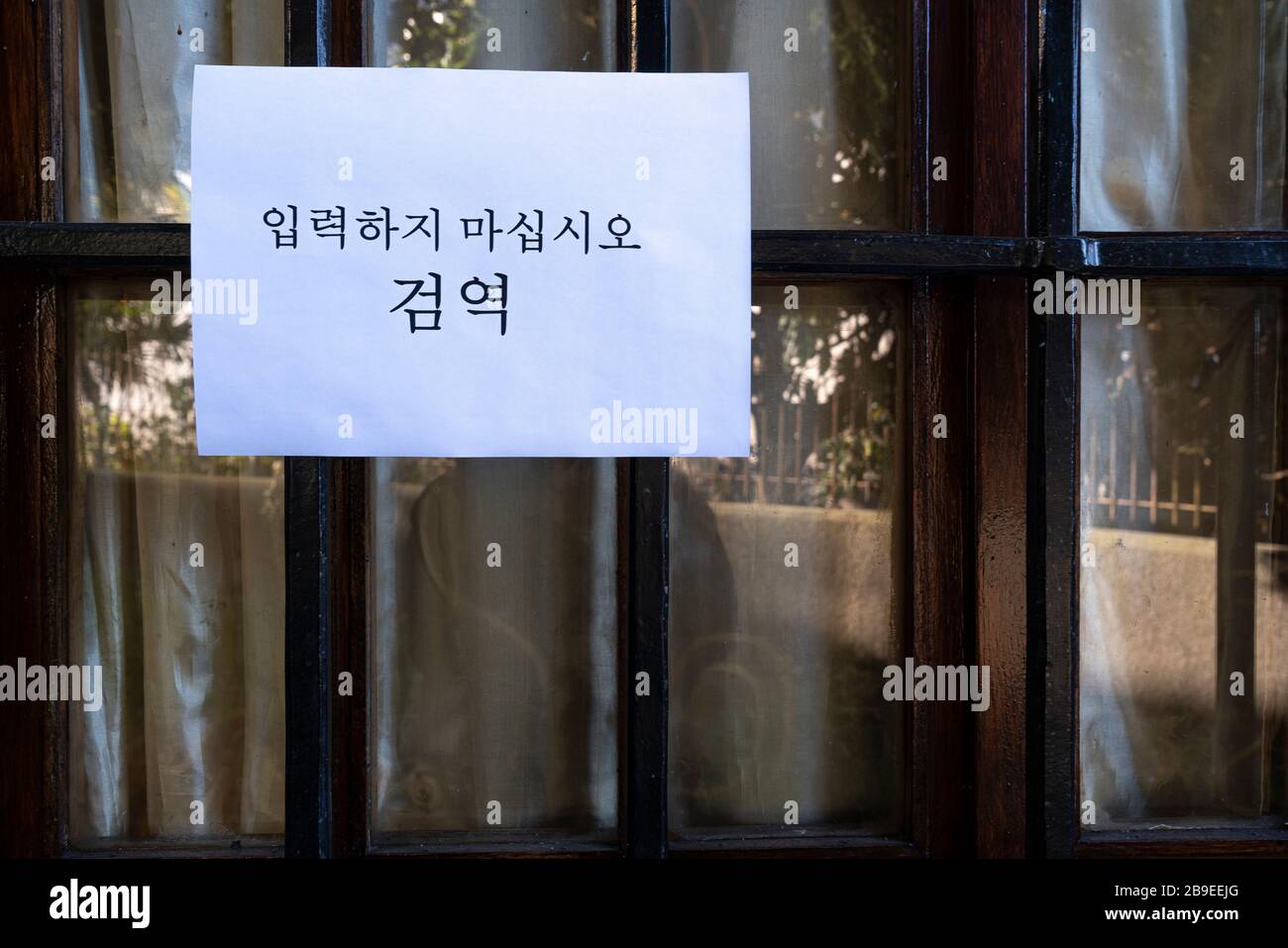 Un segno che dice non entrare, quarantena in lingua coreana allegato in una finestra Foto Stock