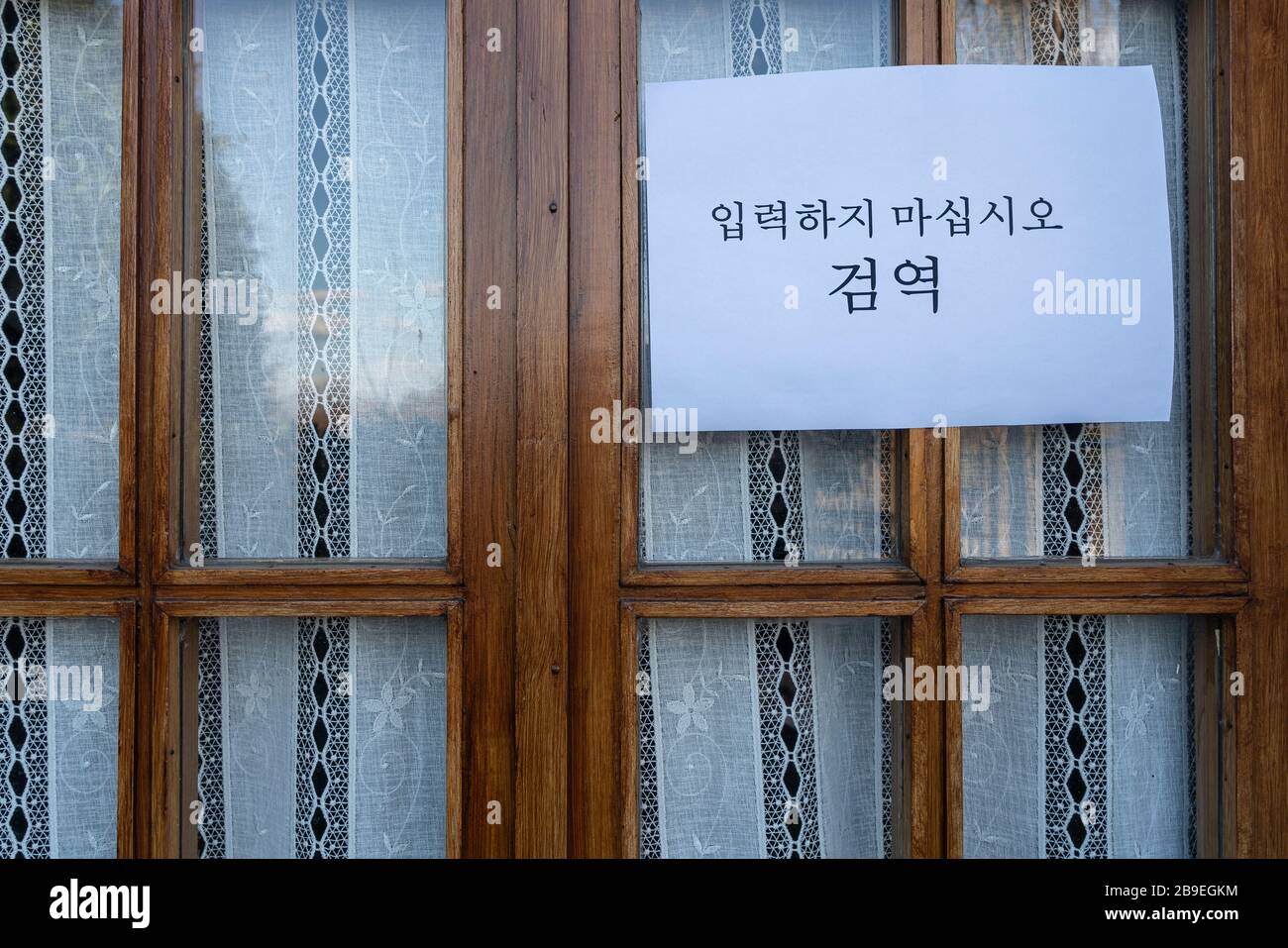 Un segno che dice non entrare, quarantena in lingua coreana allegato in una finestra Foto Stock