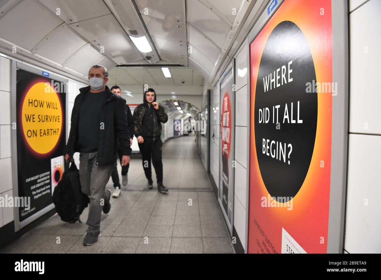 I pendolari camminano lungo un passaggio nella stazione della metropolitana di Oxford Street a Londra il giorno dopo che il primo ministro Boris Johnson ha messo il Regno Unito in un blocco per contribuire a frenare la diffusione del coronavirus. Foto Stock