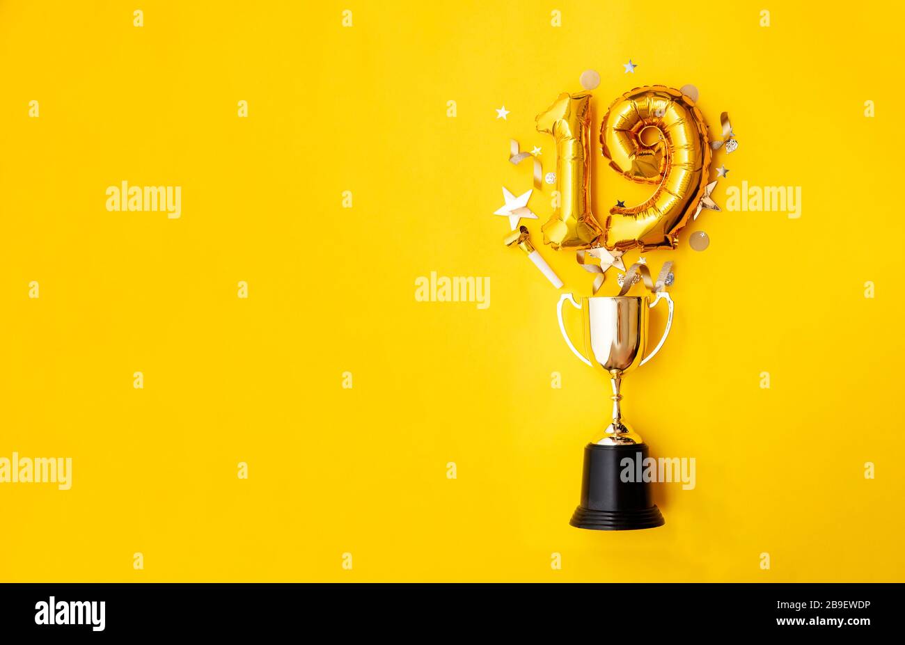 Palloncino numero 19 per la celebrazione dell'anniversario d'oro che esplode da un trofeo vincente Foto Stock