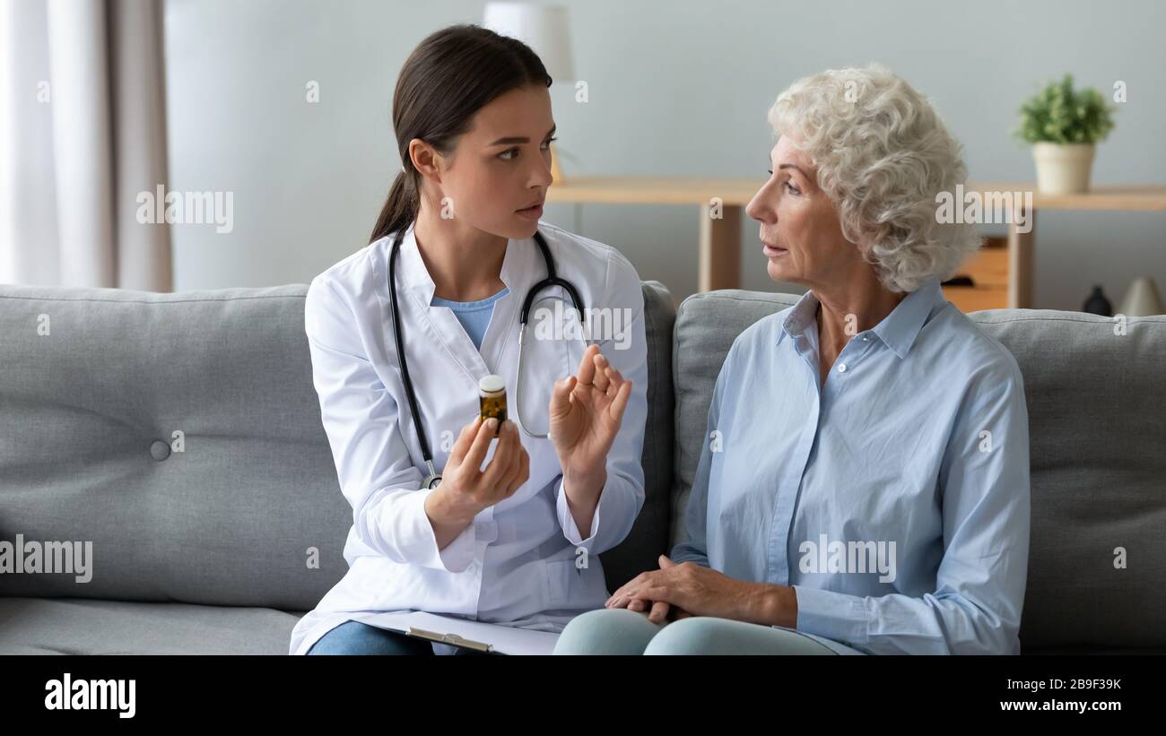 Infermiere donna prescrivere pillole a donna anziana malata Foto Stock