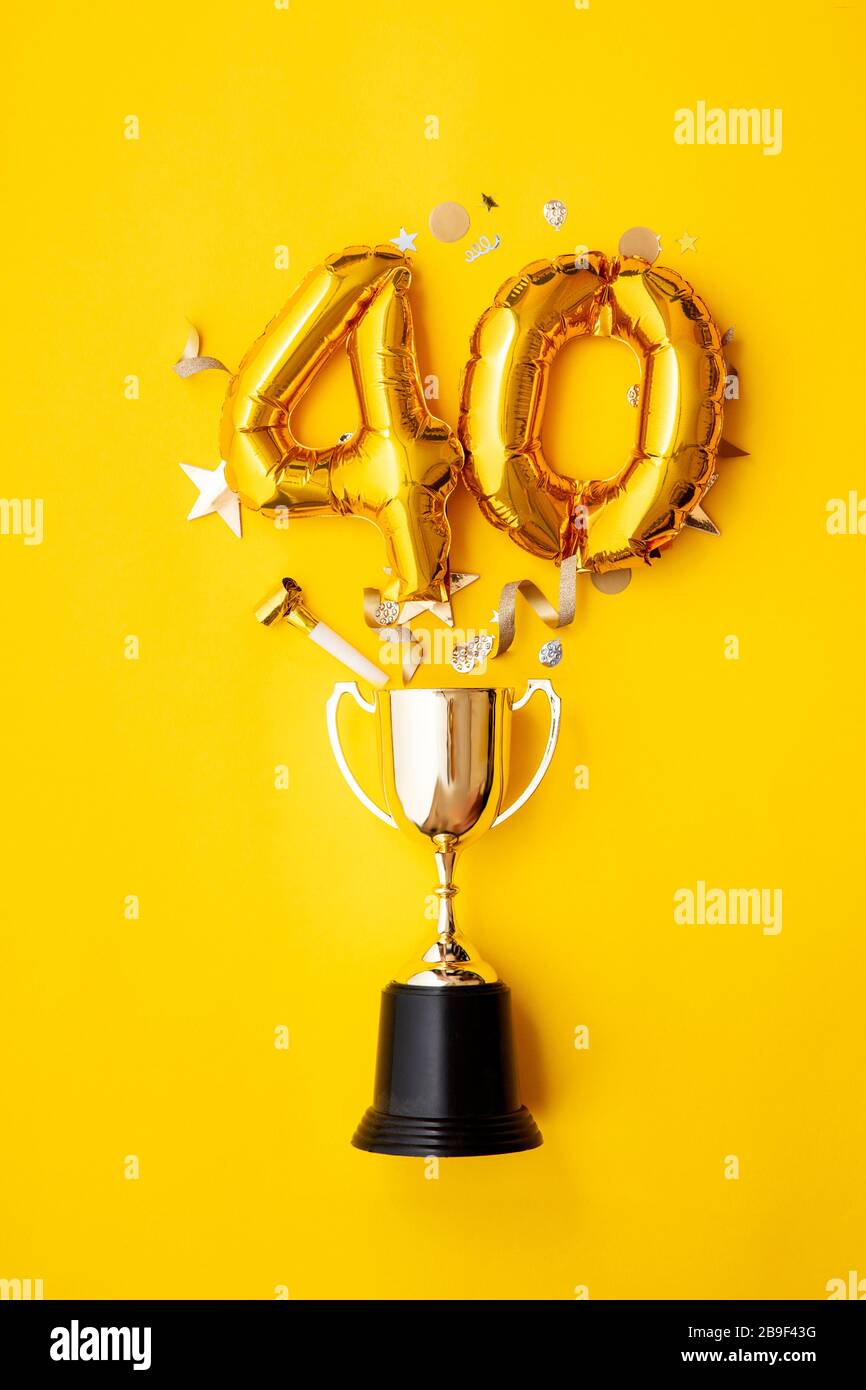 Palloncino numero 40 per la celebrazione dell'anniversario d'oro che esplode da un trofeo vincente Foto Stock
