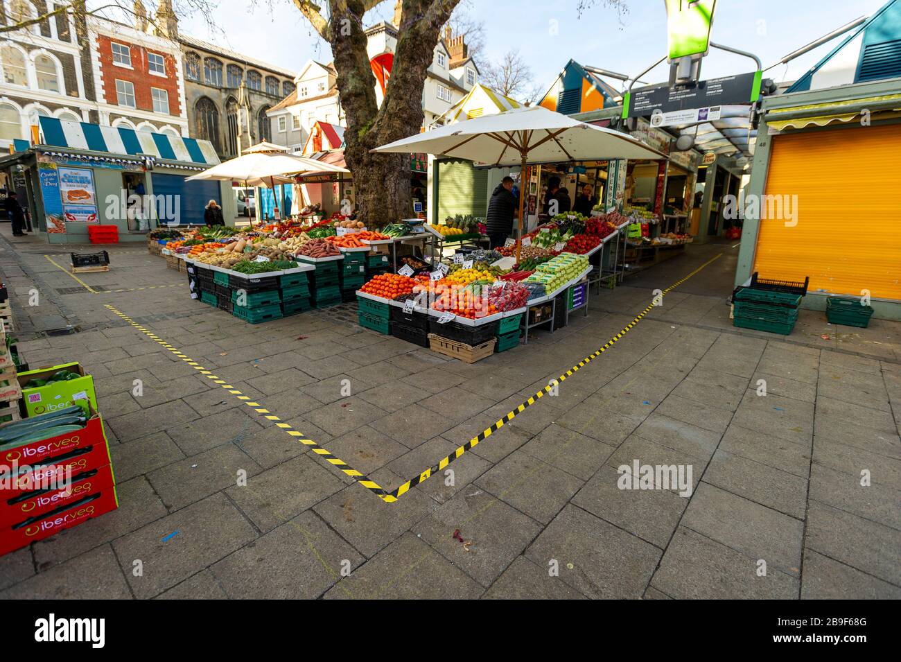 Norwich, Norfolk, UK, 24 marzo 2020. Un centro vicino vuoto a Norwich, Norfolk dopo che il Govt britannico ha esortato la gente a sty dentro durante l'emergenza di Coronavirus. Una delle bancarelle di frutta e verdura del mercato si apre con i segni di distanza sul terreno. Credit Jason Bye/Alamy Live News Foto Stock