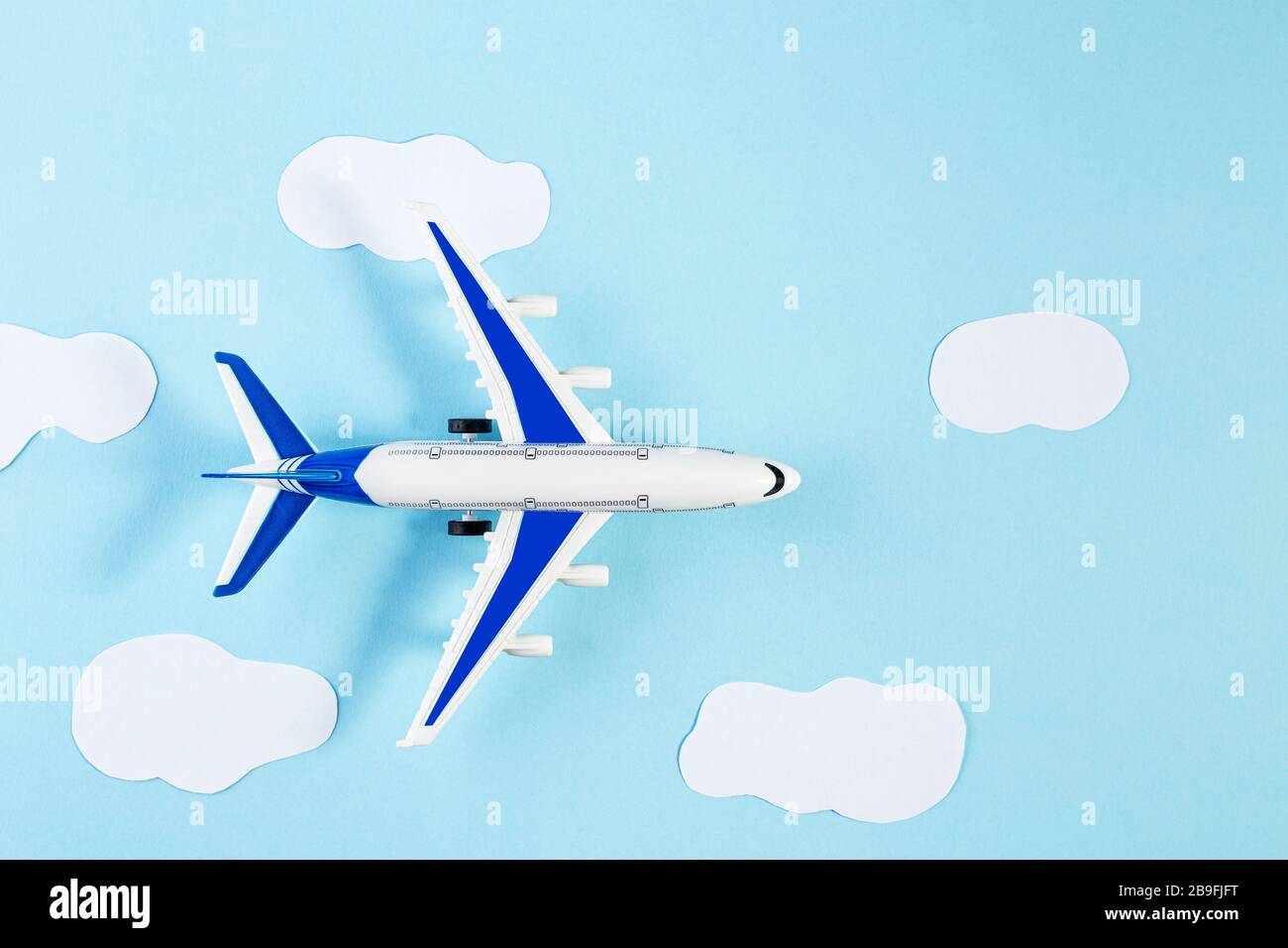 Modello aereo, aeroplano su sfondo blu color pastello. Viaggio estivo o concetto di vacanza. Piatto di aereo giocattolo in miniatura. Stile trendy minimal, co Foto Stock