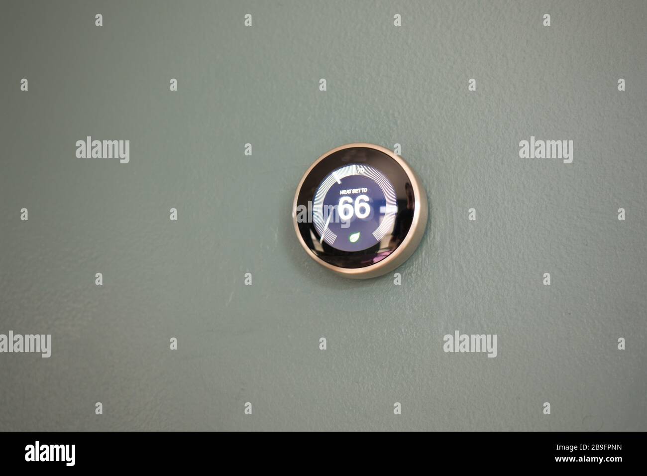 Termostato intelligente a casa con visualizzazione a 66 gradi. Regolazione della temperatura del termostato sulla parete blu per risparmiare denaro con Green TECH. Foto Stock