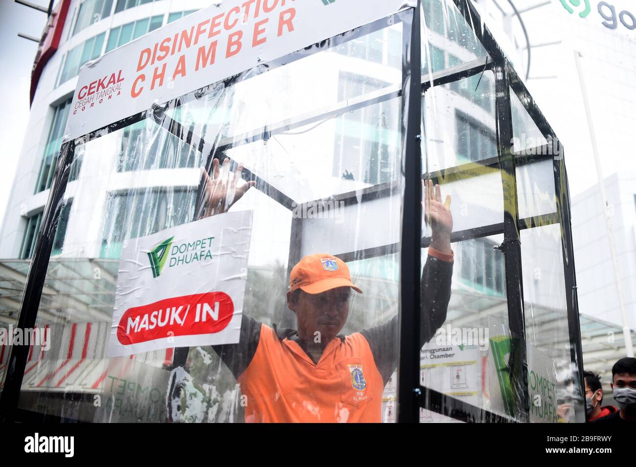 Giacarta, Indonesia. 24 Marzo 2020. La gente prova la camera di disinfezione collocata nelle aree pubbliche per impedire la diffusione del coronavirus a Jakarta, Indonesia, 24 marzo 2020. Il numero totale di decessi dovuti alla pandemia COVID-19 in Indonesia è stato superiore a 50 entro le 12:00 (ora locale) di martedì, secondo il governo indonesiano. Credit: Zulkarnain/Xinhua/Alamy Live News Foto Stock