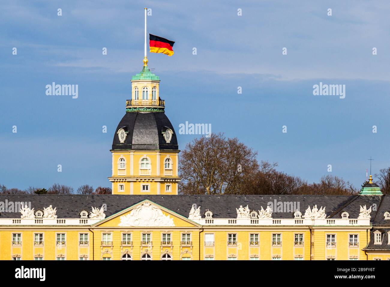 Tetto del Castello di Karlsruhe, con bandiera tedesca a Halfmast, auf Halbmast, sul tetto della torre in inverno. A Baden-Württemberg, Germania Foto Stock