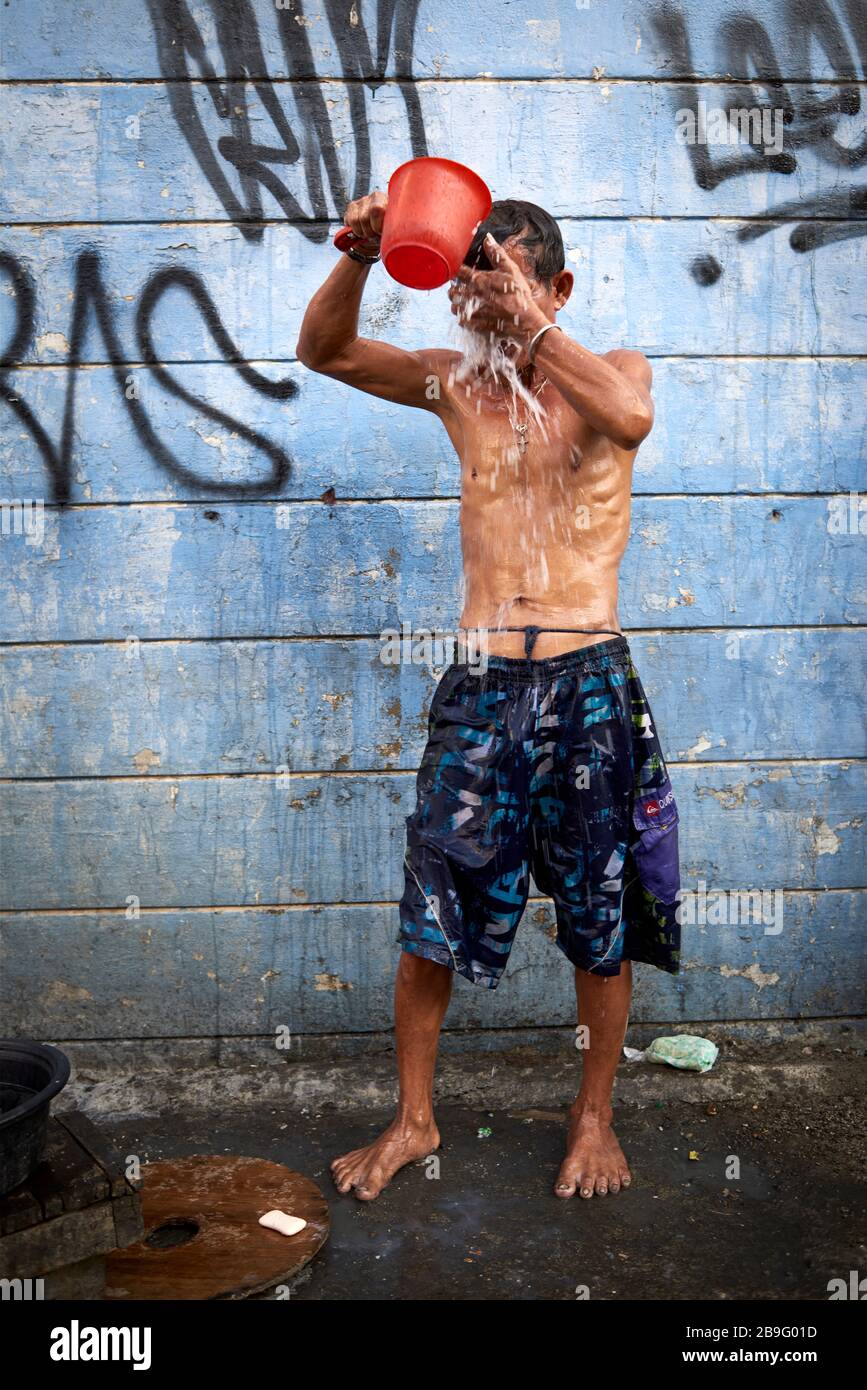 Uomo che ha un bagno con un secchio per le strade del mercato pubblico del  carbonio Foto stock - Alamy