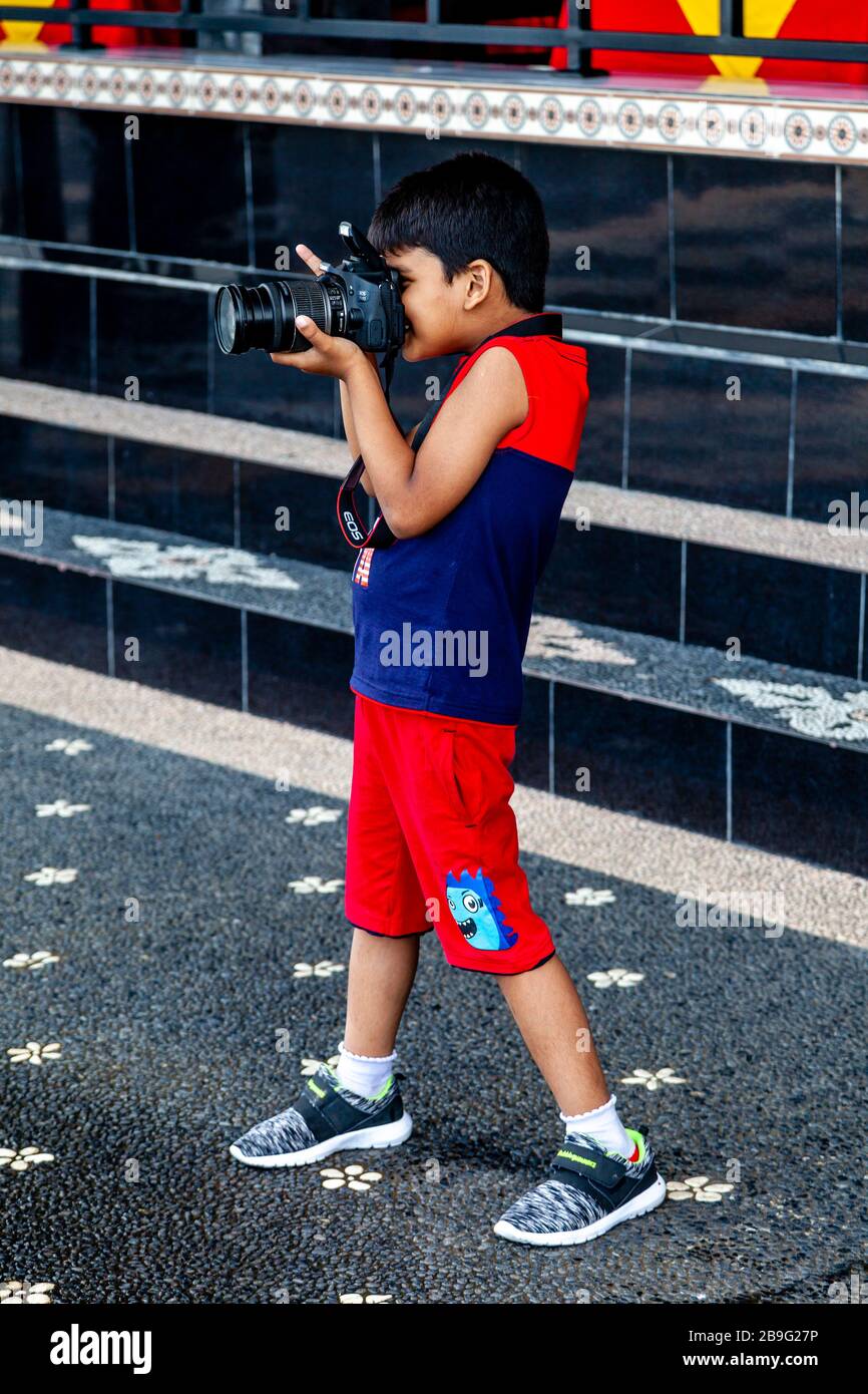 Un ragazzo giovane scattare UNA foto con una fotocamera professionale, Bali, Indonesia. Foto Stock