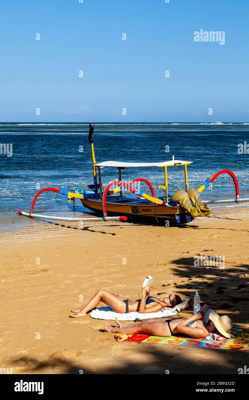 I visitatori possono prendere il sole sulla spiaggia, Sanur Beach, Sanur, Bali, Indonesia. Foto Stock