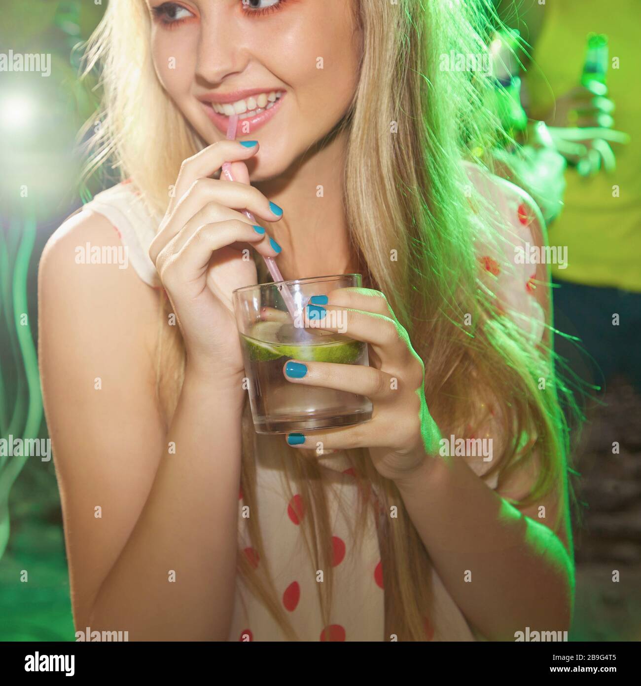 Ragazza adolescente felice che beve a festa Foto Stock