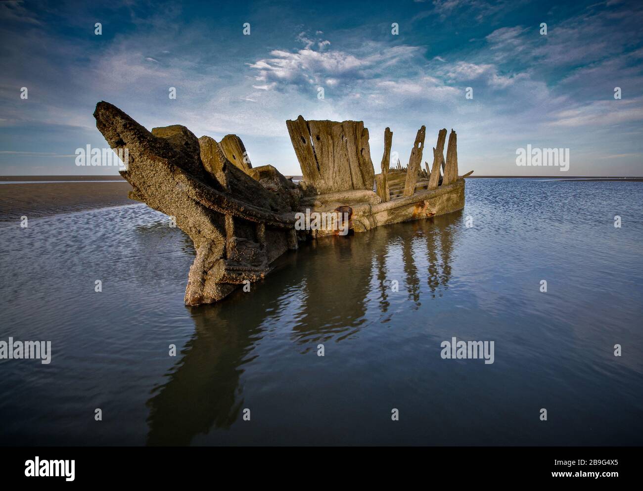 Un naufragio di legno sulla costa di Sefton occasionalmente si affaccia dalla sabbia Foto Stock
