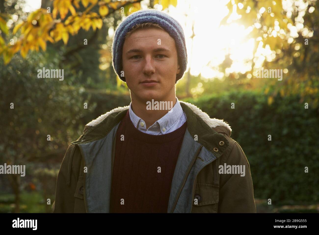 Ritratto ragazzo adolescente fiducioso in autunno parco Foto Stock