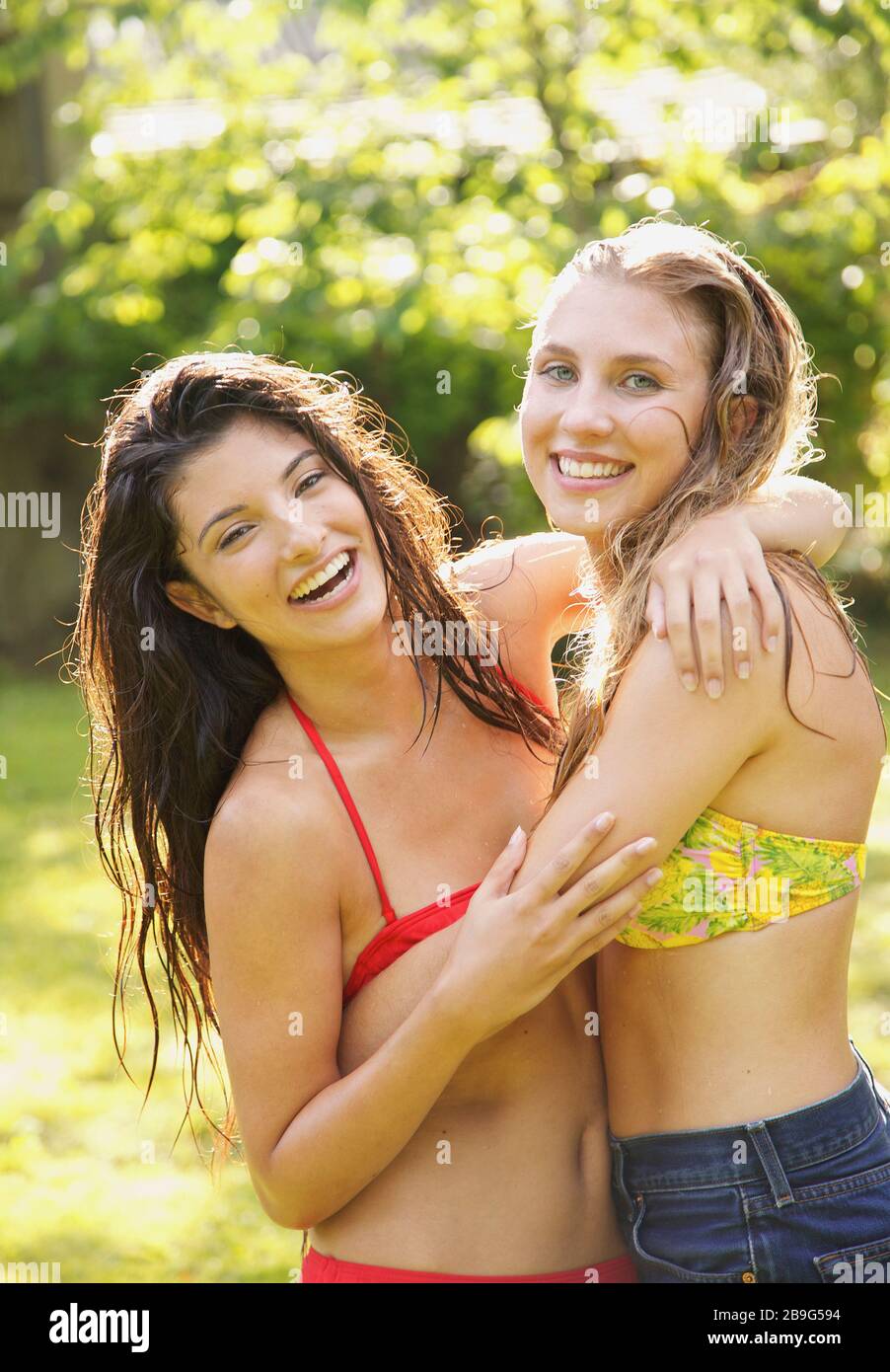 Ritratto felice giovani donne amici in bikini top abbracciare Foto Stock
