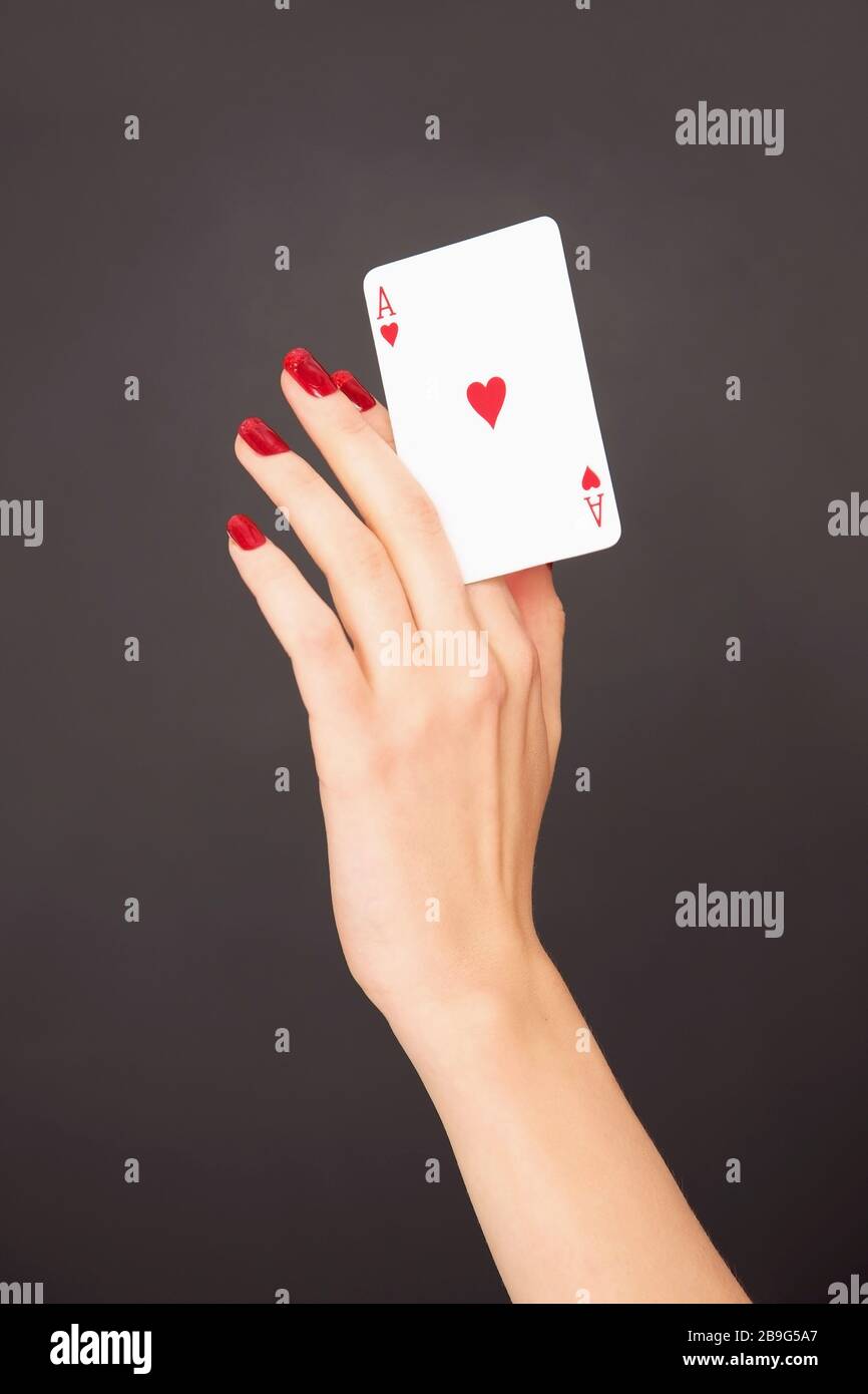 Donna ritratto con unghie rosse che tiene carta Ace of Hearts Foto Stock