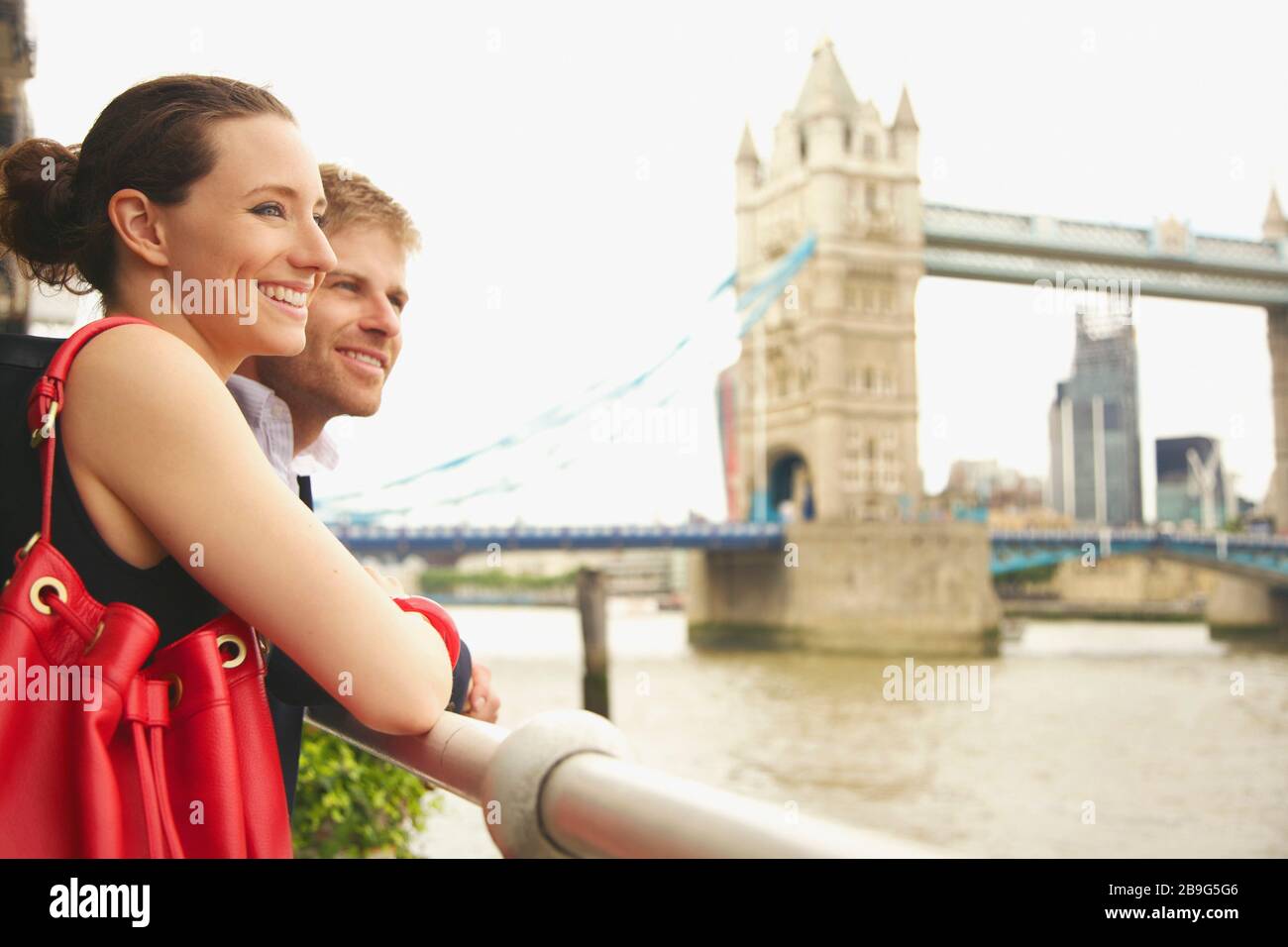 Giovane coppia felice godendo di vista del Tamigi e del Tower Bridge, Londra Foto Stock