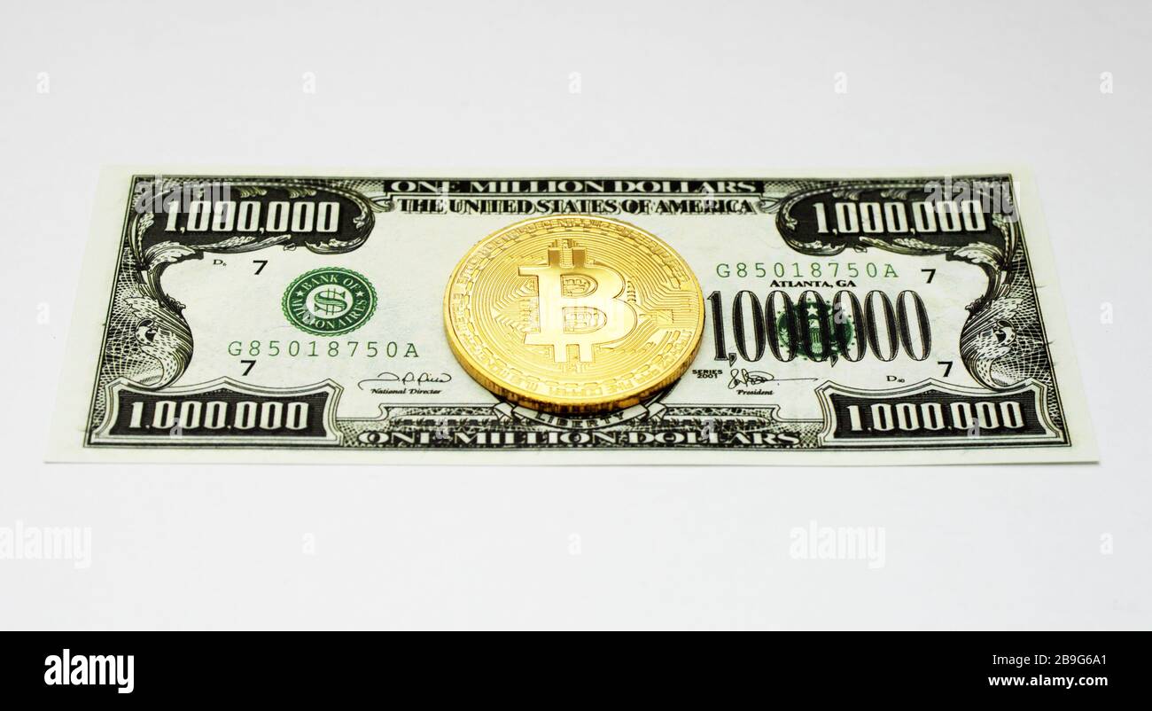 golden bitcoin si trova su un milione di dollari bill, sfondo bianco, isolato Foto Stock