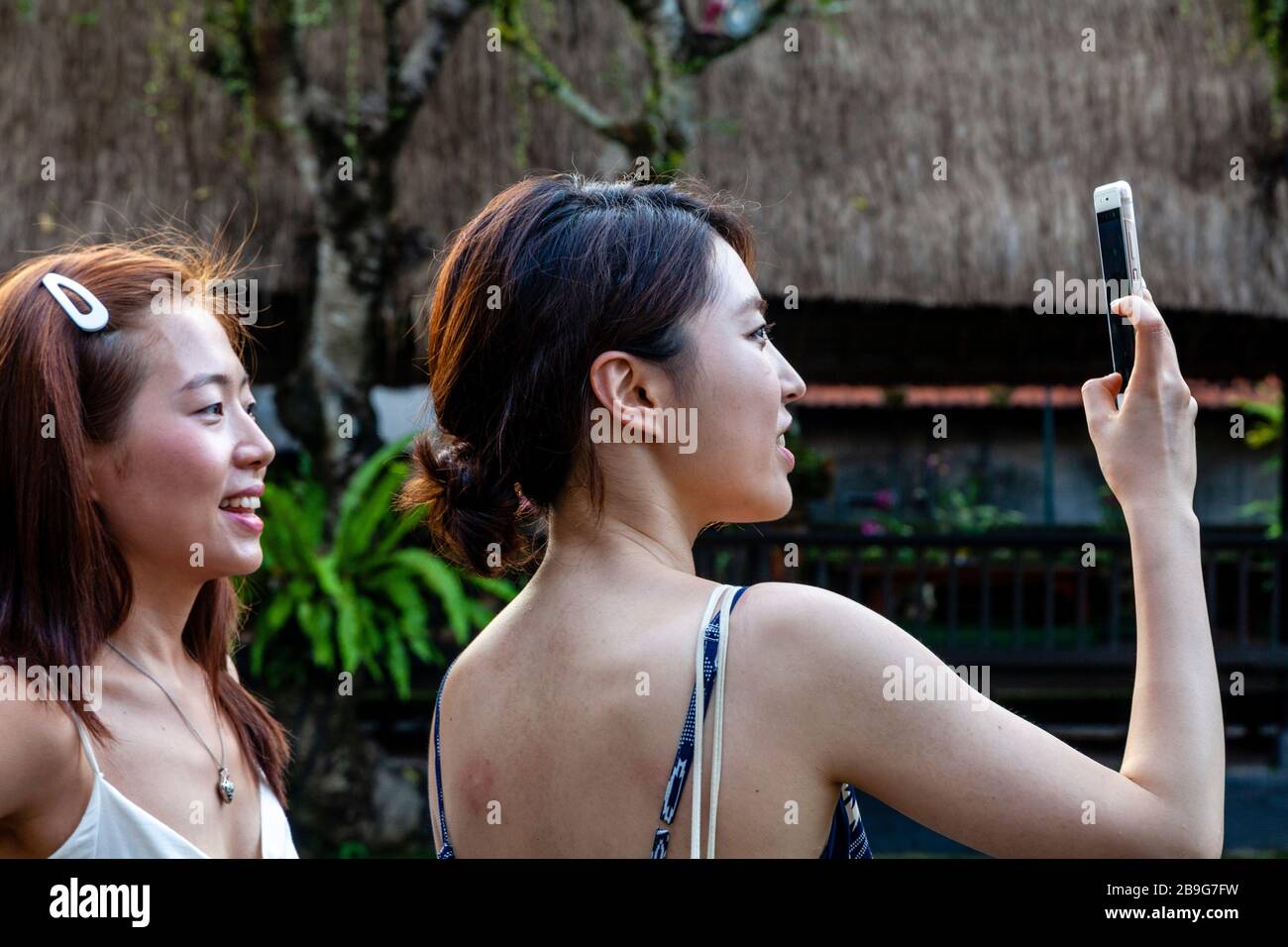 Turisti asiatici che prendono le foto a pura Taman Saraswati, Bali, Indonesia. Foto Stock