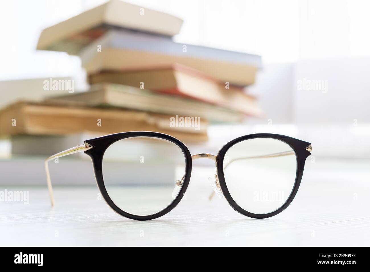 occhiali con libri sullo sfondo Foto Stock