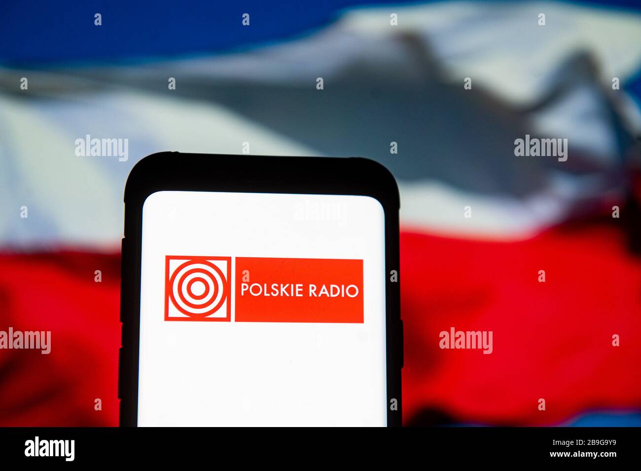 In questa immagine viene visualizzato sullo smartphone un logo Polskie radio (Polish radio).la bandiera nazionale polacca viene visualizzata come sfondo. Foto Stock