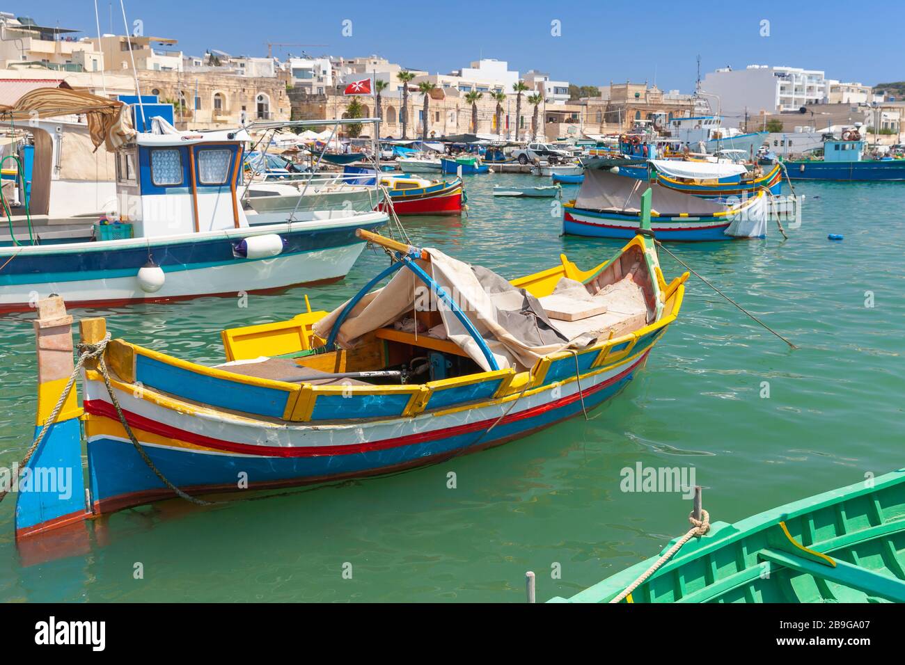 Colorate barche da pesca tradizionali maltesi ormeggiate a Marsaxlokk, Malta Foto Stock