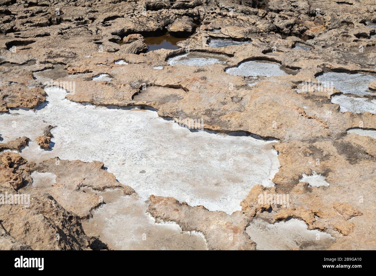 Il sale si trova sulle rocce costiere della costa del Mare interno, Gozo, Malta Foto Stock