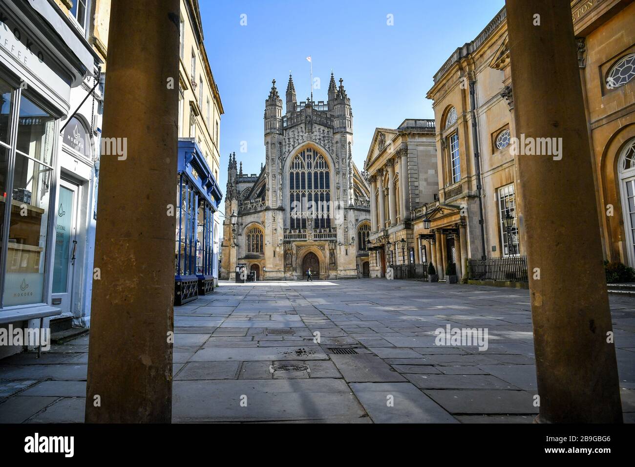 Il cortile dell'abbazia di Bath e l'ingresso alle terme romane sono vuoti di visitatori il giorno dopo che il primo ministro Boris Johnson ha messo il Regno Unito in una situazione di blocco per contribuire a frenare la diffusione del coronavirus. Foto Stock