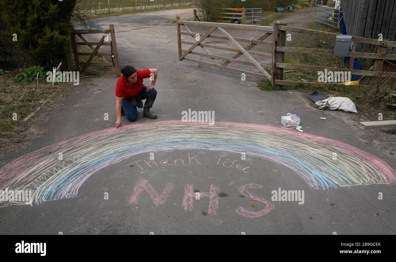 Christina Quigley, 43, da Conkers asilo all'aperto in Rolands Gill, disegno di un arcobaleno sulla sua proprietà con un messaggio di ringraziamento al NHS, il giorno dopo il primo Ministro Boris Johnson mettere il Regno Unito in blocco per contribuire a frenare la diffusione del coronavirus. Foto Stock