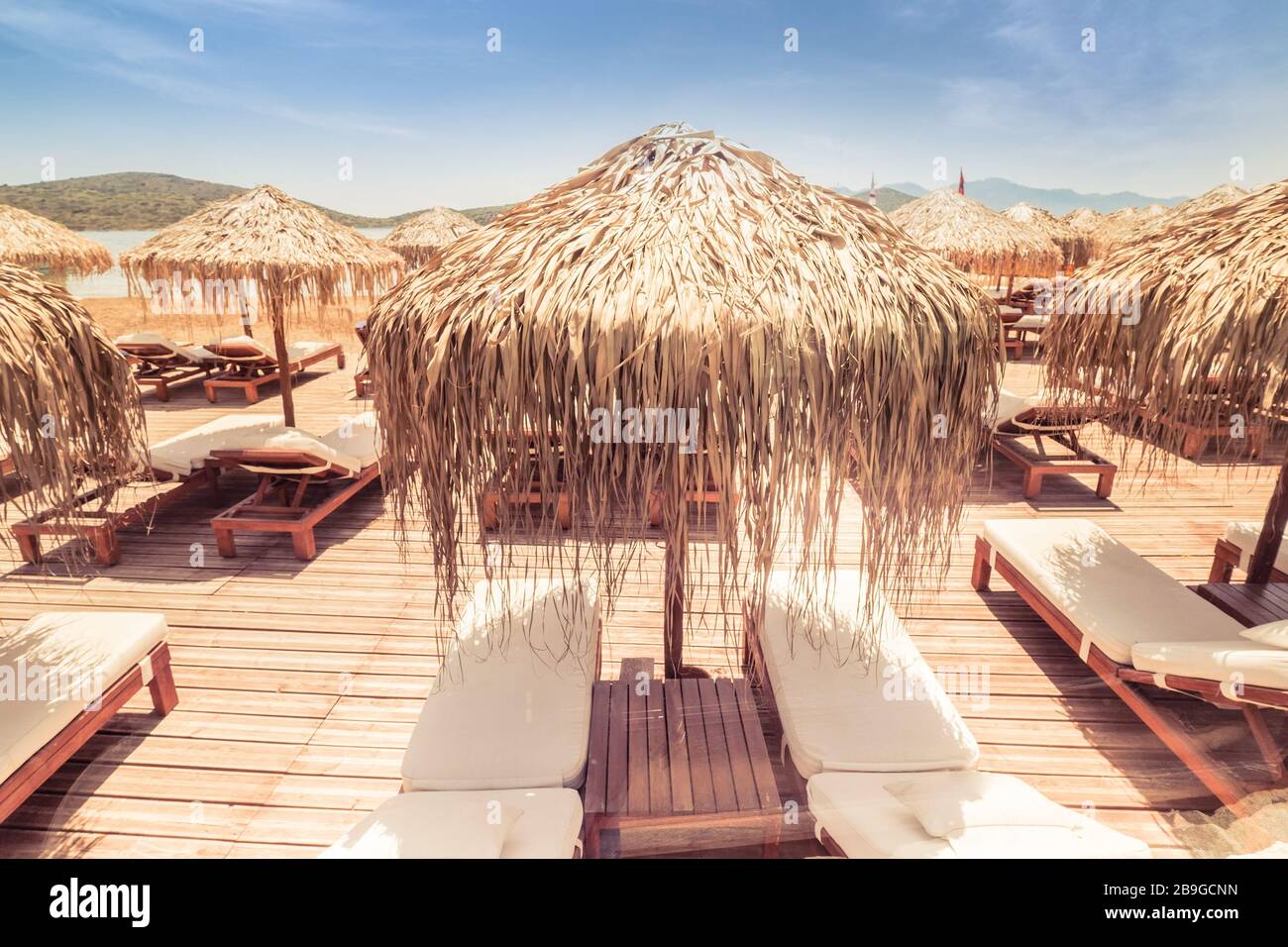 Vista astratta di un incredibile paesaggio da spiaggia con ombrello di paglia vicino all'azzurro del Mar Egeo. Giornata di sole nel paradiso mediterraneo. Isola di Creta, Grecia. Romant Foto Stock