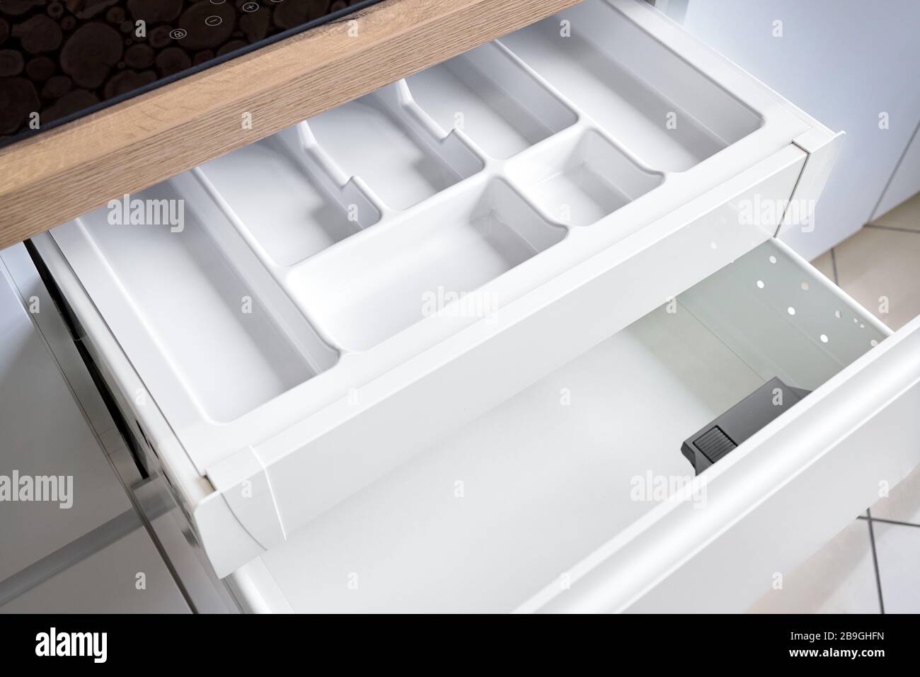 Soluzione per mettere gli utensili da cucina in cucina moderna - orizzontale scorrevole cassetti scaffali di stoccaggio in armadio per utensili da cucina pentole sotto Foto Stock