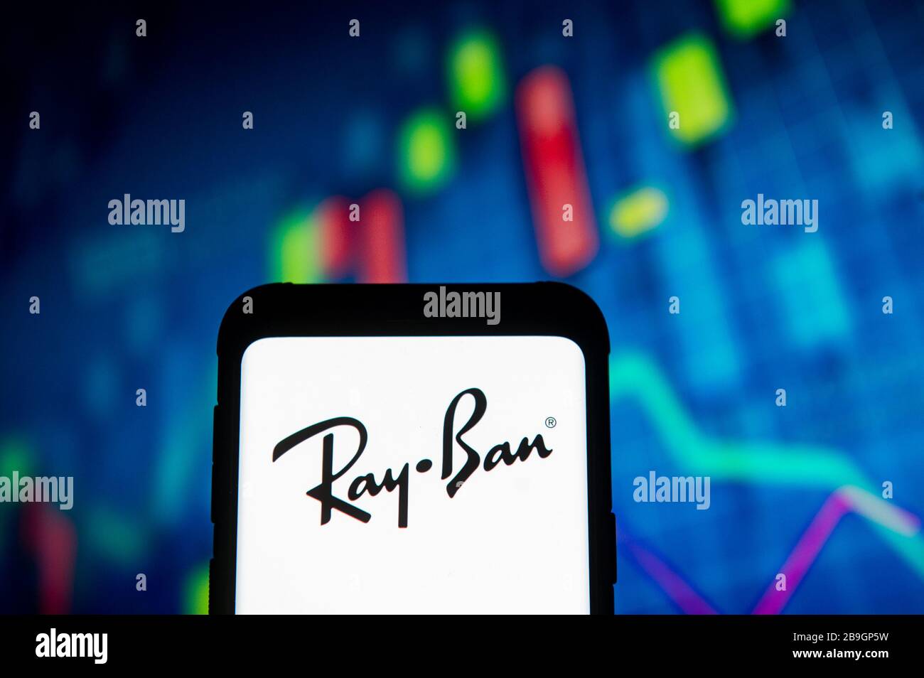 Polonia. 23 marzo 2020. In questa immagine viene visualizzato un logo Ray Ban su uno smartphone.VIENE visualizzata UNA tabella del mercato azionario come sfondo. Credit: Mateusz Slodkowski/SOPA Images/ZUMA Wire/Alamy Live News Foto Stock