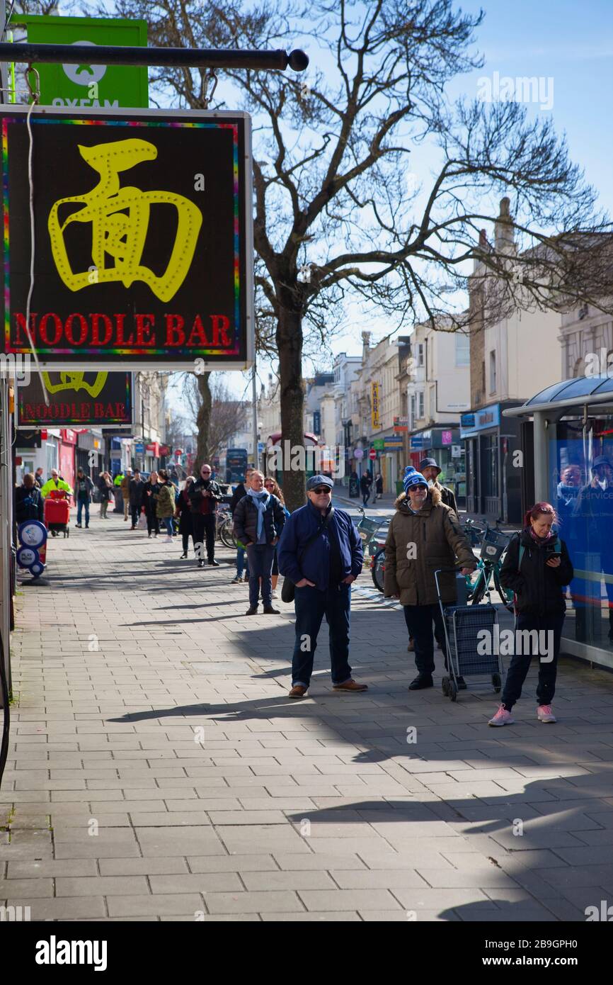 Inghilterra, East Sussex, Brighton, persone in coda con le misure di distanza sociale messe in atto dal supermercato Waitrose per limitare le persone che entrano nel negozio. Foto Stock